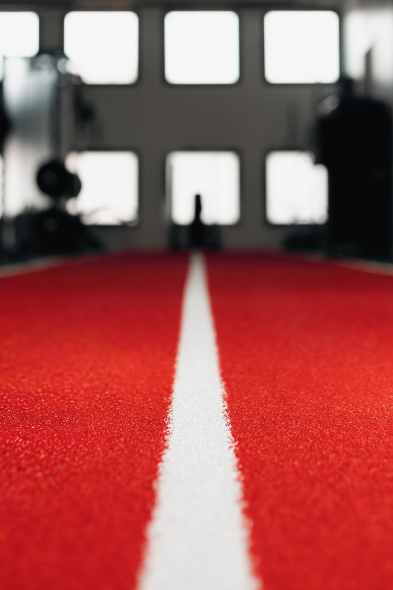 Piste d'athlétisme intérieure rouge avec ligne blanche centrale