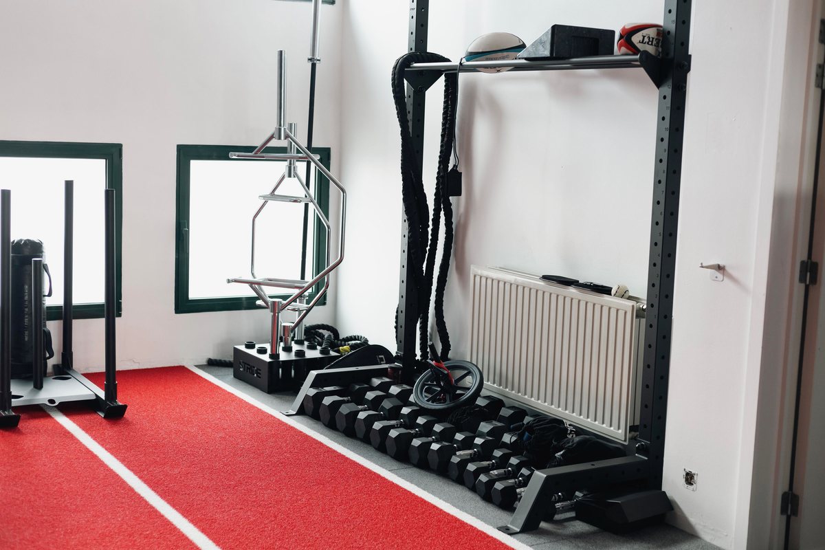 Haltères et kettlebells alignés le long de la piste rouge